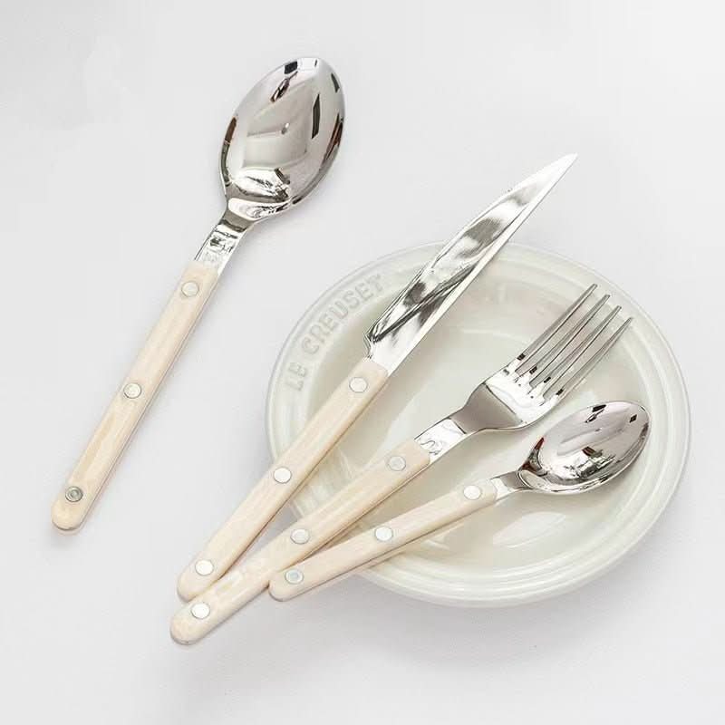 Luxurious 24-piece engraved stainless steel cutlery set, perfect for a refined table setting.