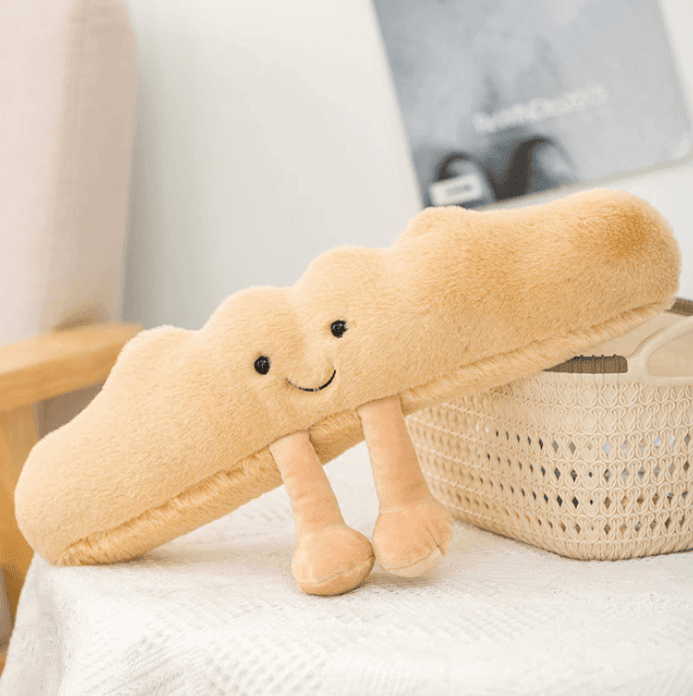 Adorable unisex croissant plush toy. Soft, huggable pastry stuffed animal, perfect as a cute comfort toy for kids.