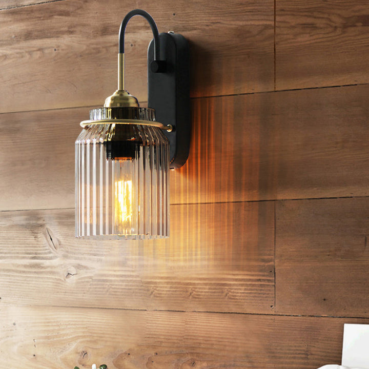 Black farmhouse wall sconce with prismatic glass shade, perfect for indoor home lighting.