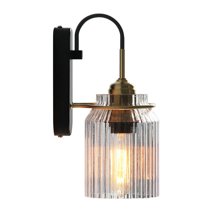 Single black metal farmhouse wall sconce featuring unique prismatic glass for ambient indoor light.