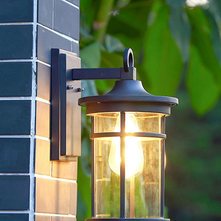 Black industrial outdoor wall sconce with glass shade for garden & patio lighting, weatherproof aluminum.