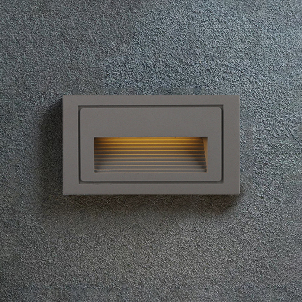 Modern grey LED step light for enhancing deck aesthetics.