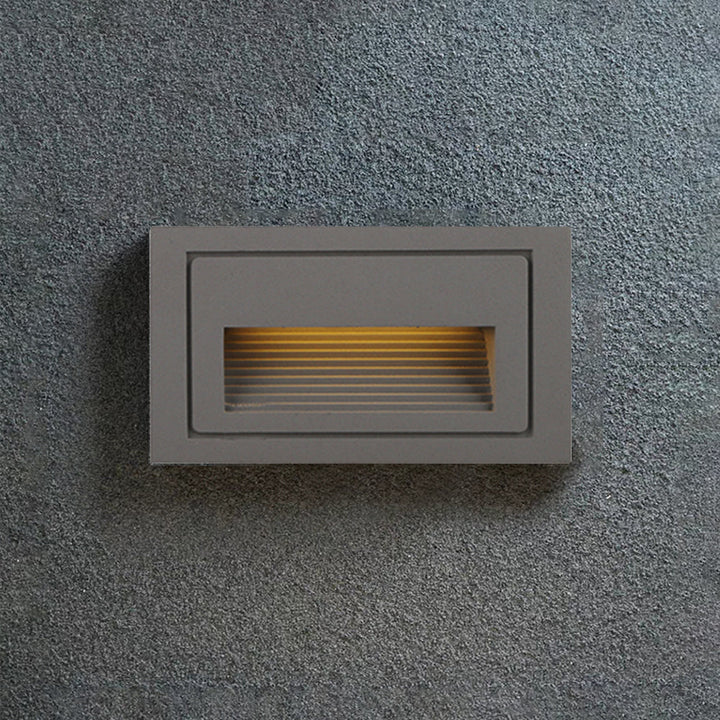 Modern grey LED step light for enhancing deck aesthetics.