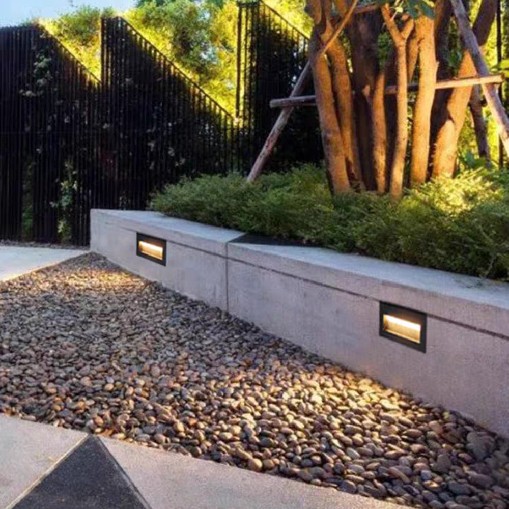 Modern grey LED deck light illuminates outdoor steps safely.