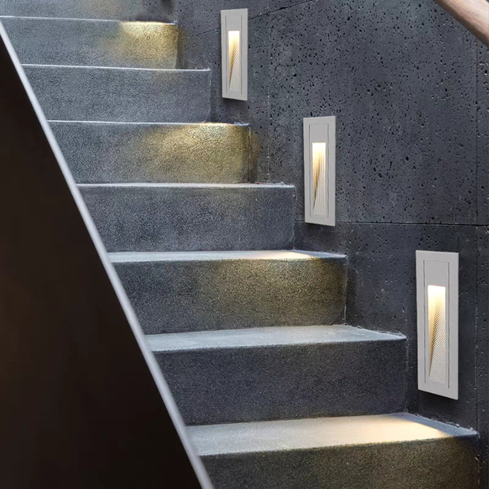 White hardwired LED pathway light for exterior stairs.