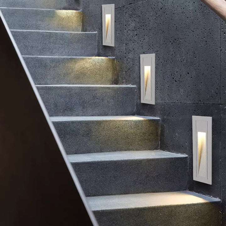 White hardwired LED pathway light for exterior stairs.