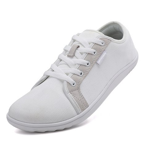 Texture shot of breathable material on white zero-drop comfort shoes, promoting natural foot health.