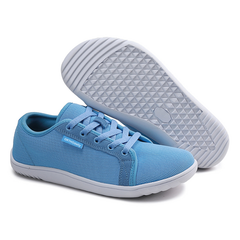 Person wearing gray zero-drop comfort walking shoes, demonstrating natural stride & wide toe box.