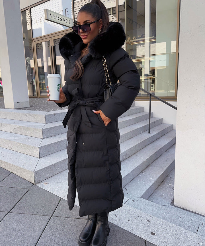 Elegant women's long black puffer coat with belt, quilted design, perfect for winter fashion.