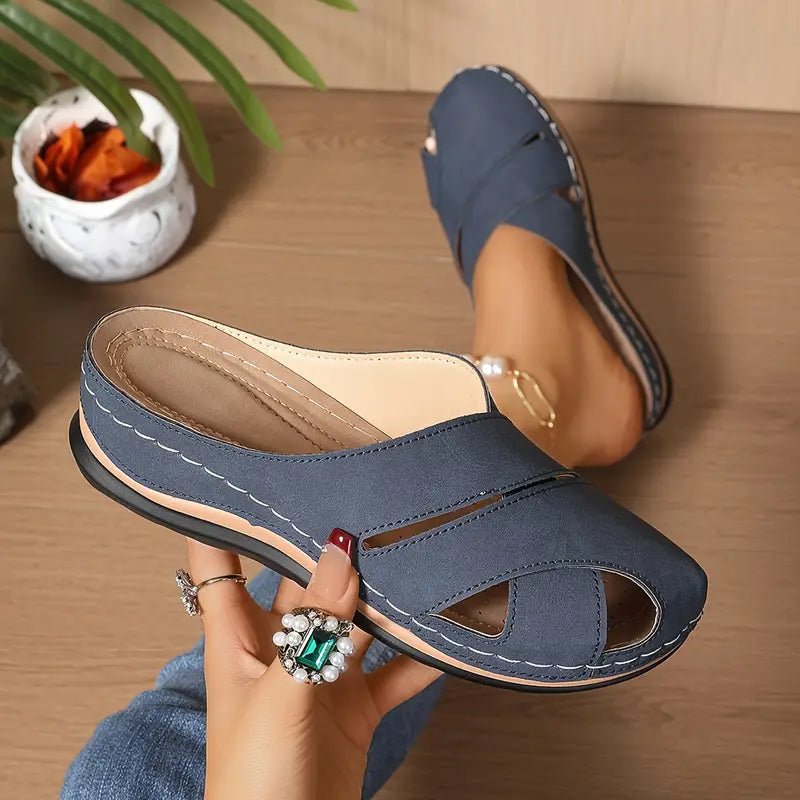 Blue women's breathable cross-strap mule sandals. Stylish slip-on flat summer comfort footwear.