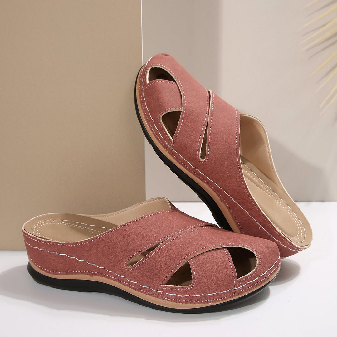 Pink women's breathable cross-strap mule sandals. Comfortable slip-on flats for casual summer wear.