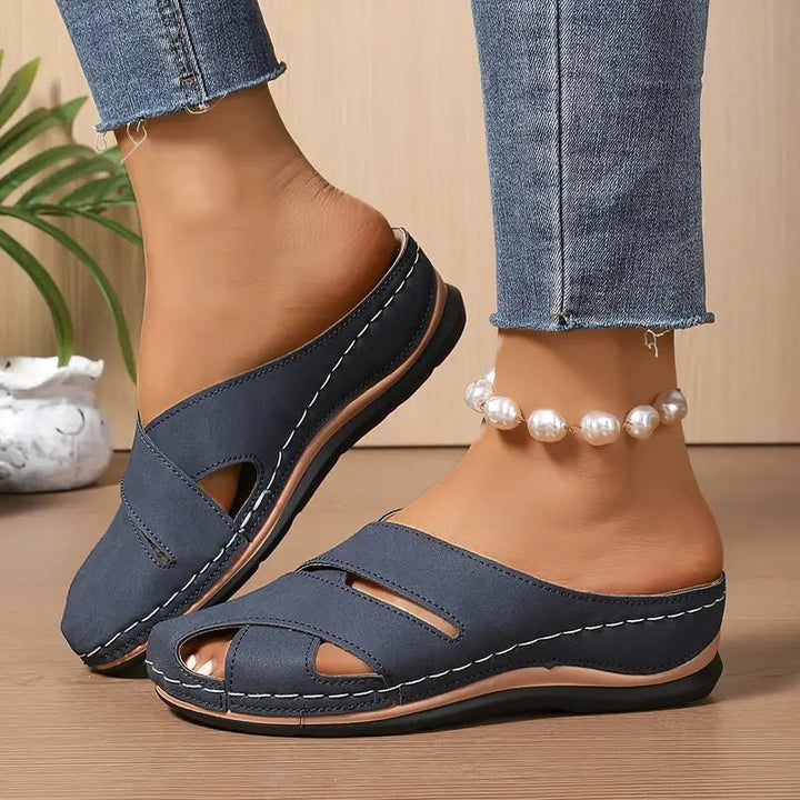 Women's black breathable cross-strap mule sandals. Comfortable flat slip-on for summer casual outfits.