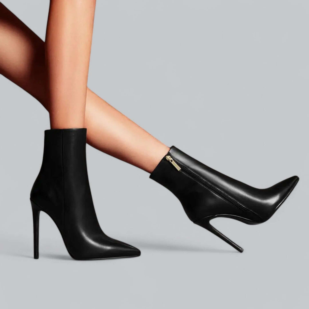 Back view of women's black pointed toe stiletto ankle boots, high heel fashion.