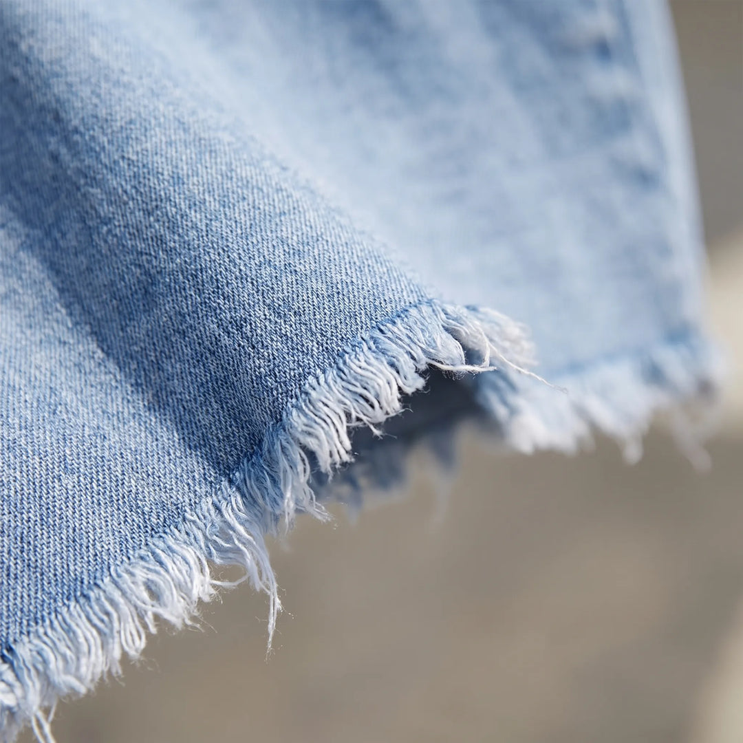 Elegant women's midi skirt in blue, featuring a high waist, pleats, and a frayed hem for versatile comfort.