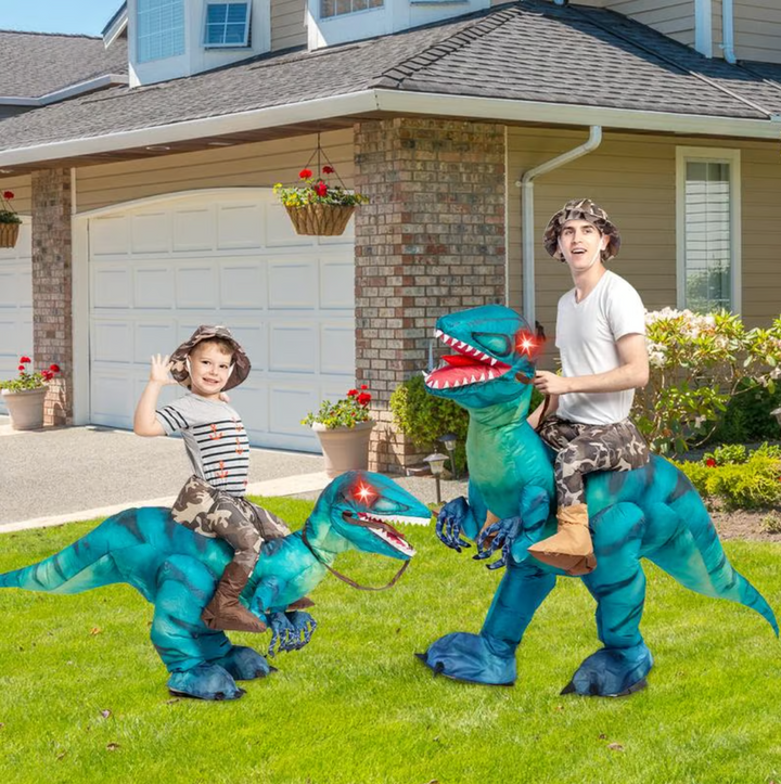Kids laughing on a large inflatable red dino ride-on, enjoying a fun outdoor party game.