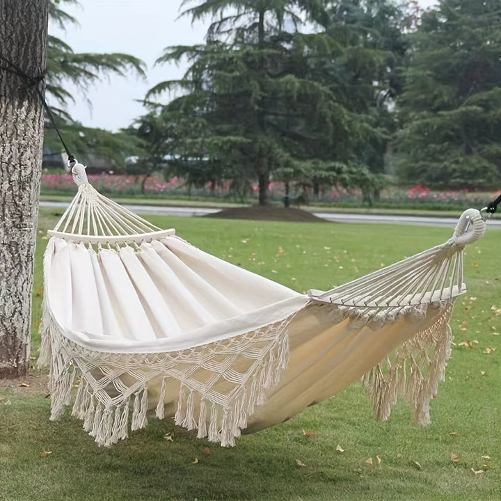 Relaxing double hammock with fringe tassels, great for indoor comfort & bohemian style.