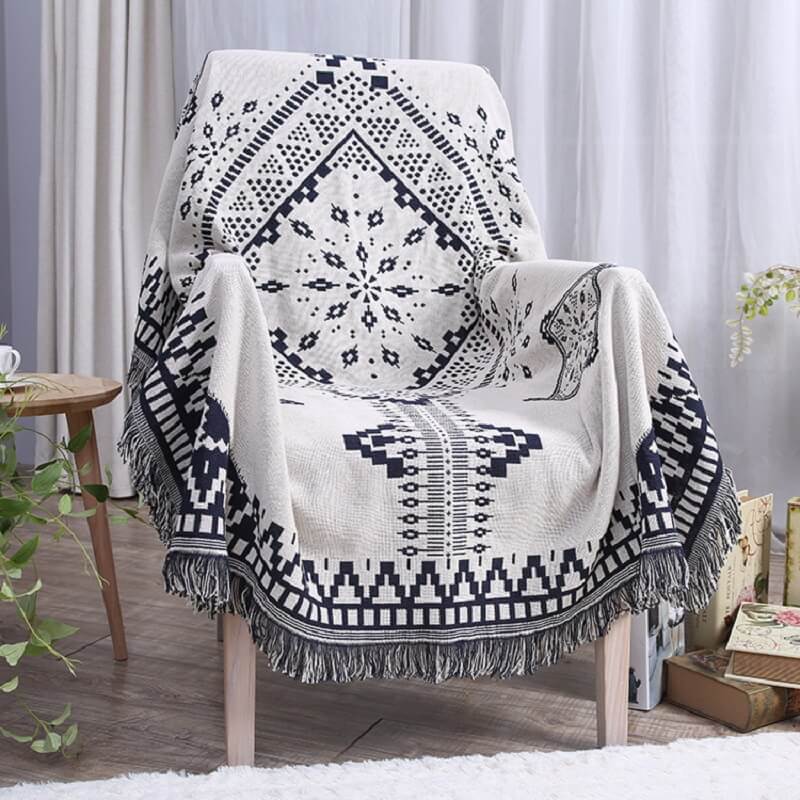 Cozy bohemian knitted throw blanket featuring tassels. Stylish living room accent.
