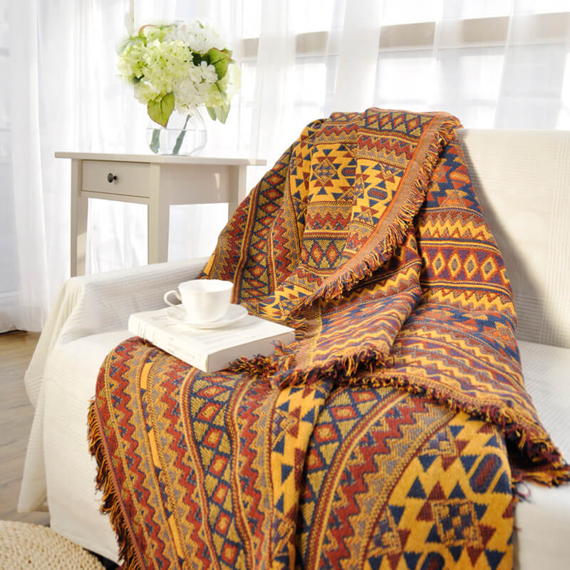 Reversible knitted bohemian throw with tassels. A cozy blanket for stylish living rooms.