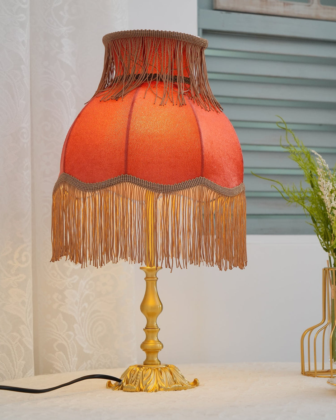 Modern eclectic red table lamp, bohemian charm with a warm-toned tassel design.