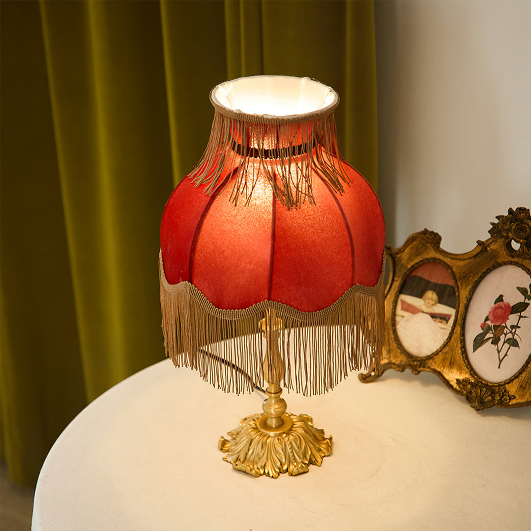 Bohemian style red table lamp, perfect for a living room with its inviting warm glow.