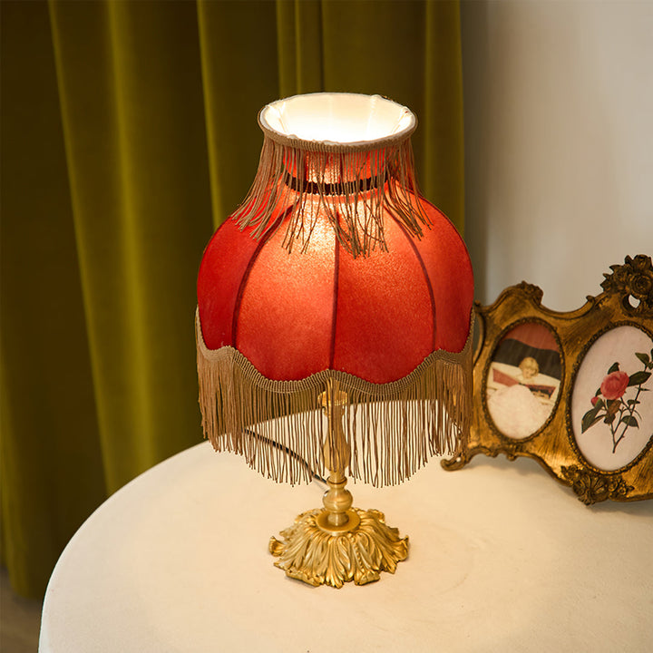 Bohemian style red table lamp, perfect for a living room with its inviting warm glow.