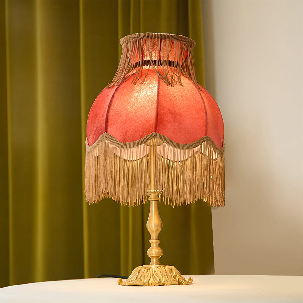 Accent lighting: red table lamp with bohemian tassels, adds warmth to any bedroom or living area.