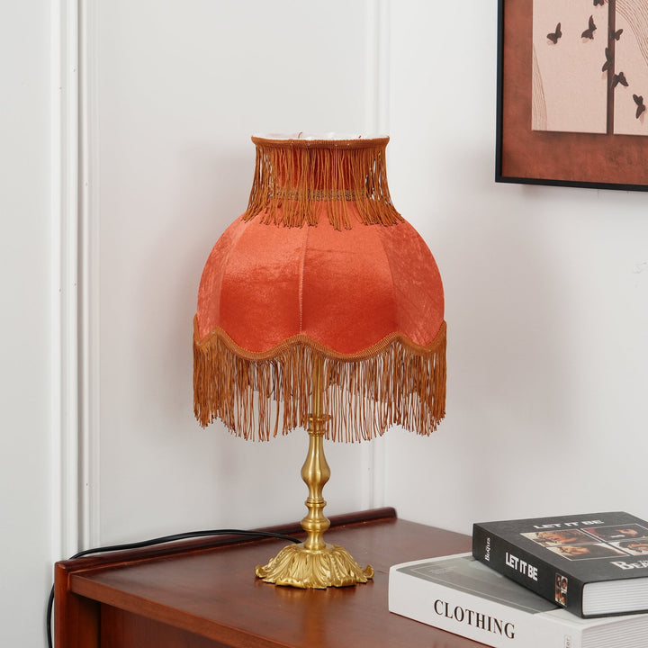 Decorative red table lamp, modern eclectic design with tassel accent, ideal for living rooms.