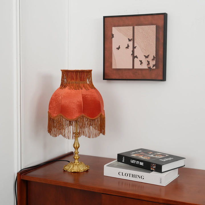 Bohemian red table lamp, warm light and decorative tassels create a cozy atmosphere.