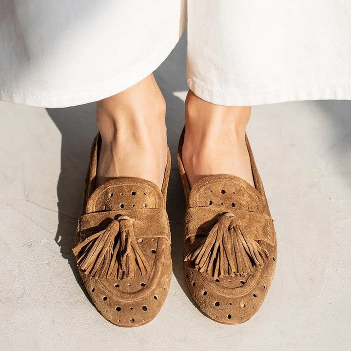 Brown women's perforated tassel loafers. Comfortable slip-on shoes for elegant everyday style.