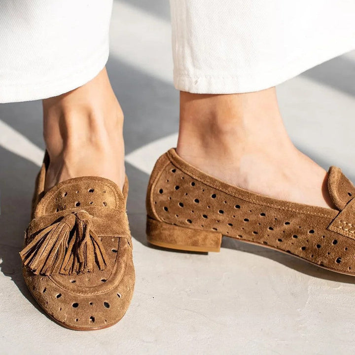 Stylish women's brown loafers with perforated design & tassels. Comfortable fashion slip-on shoes for casual wear.
