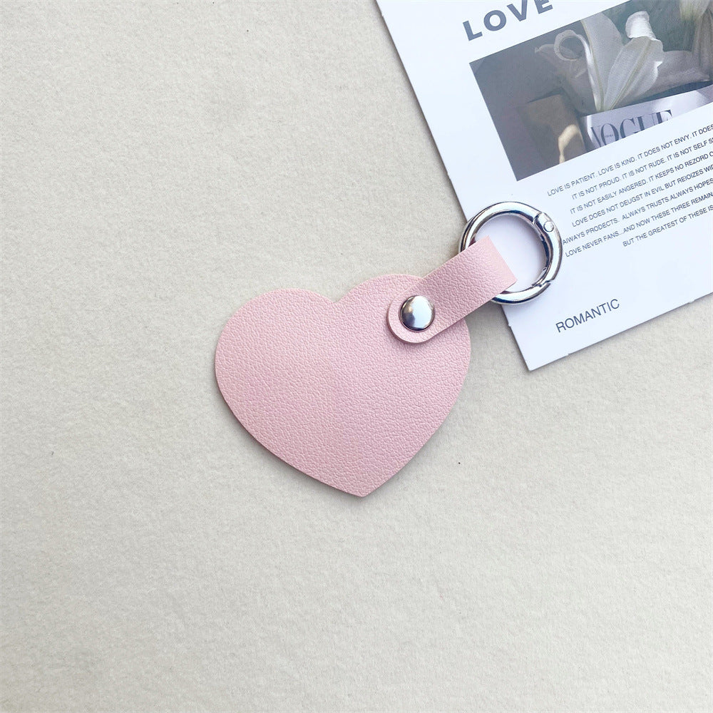 Detailed close-up of a leather heart keychain, showing texture. Stylish key & bag charm accessory.