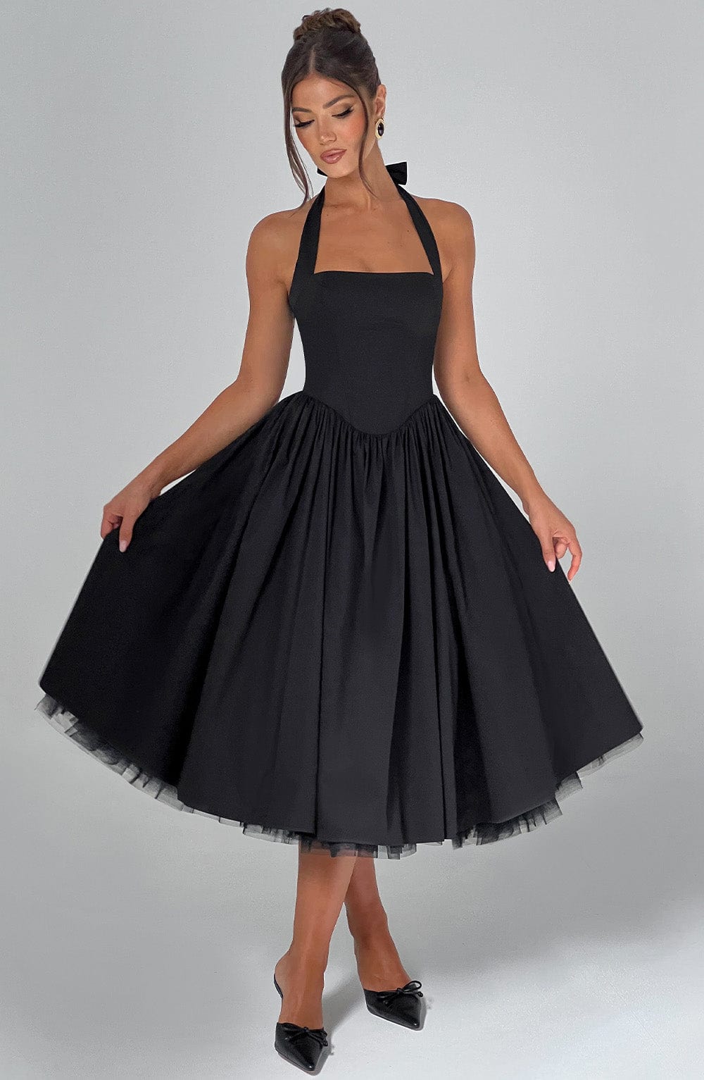 White midi dress with a halter neckline. Elegant women's formal wear for wedding guests and parties.