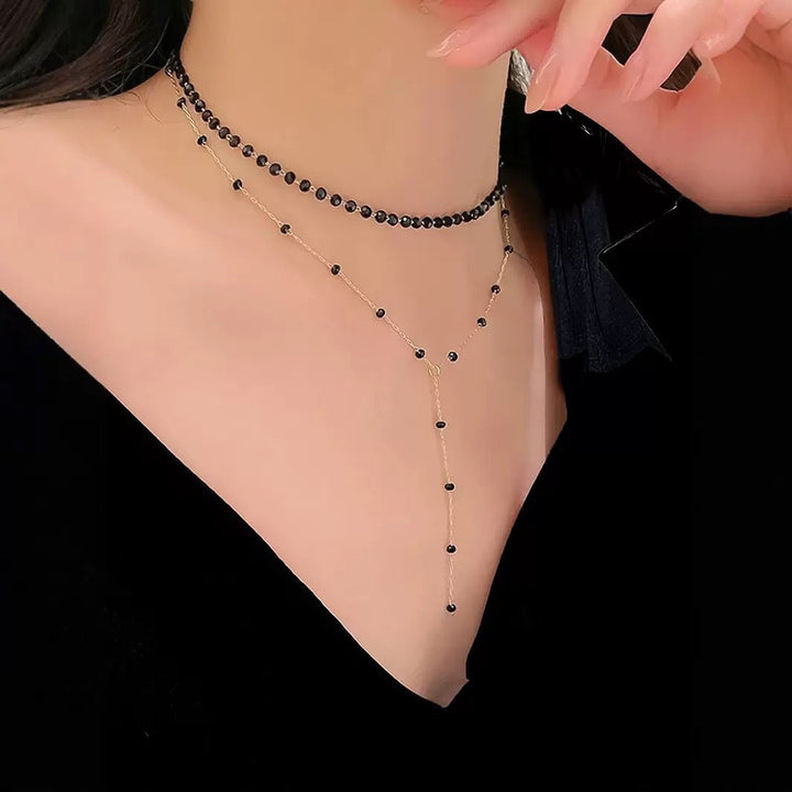Elegant women's layered choker necklace with a delicate black pendant. Stylish fashion accessory.