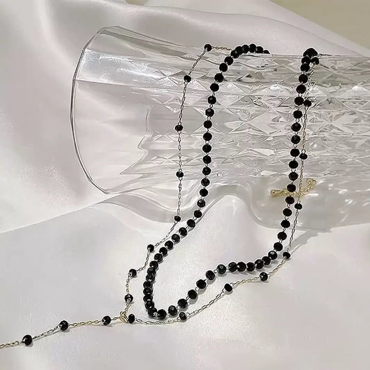 Women's sophisticated black layered choker necklace with a subtle pendant. Versatile fashion jewelry.