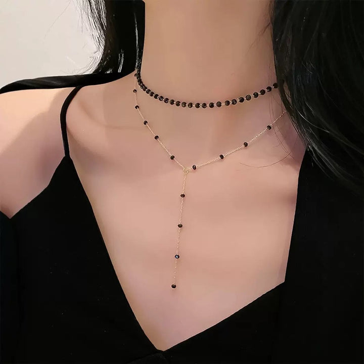 Sleek black layered choker pendant necklace. Modern women's fashion jewelry, ideal for chic looks.