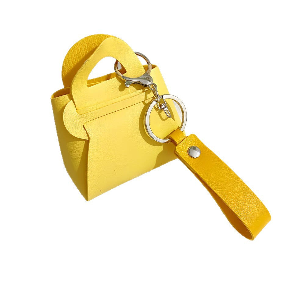 Faux leather miniature handbag keychain with gold hardware. Stylish bag charm for women's keys.