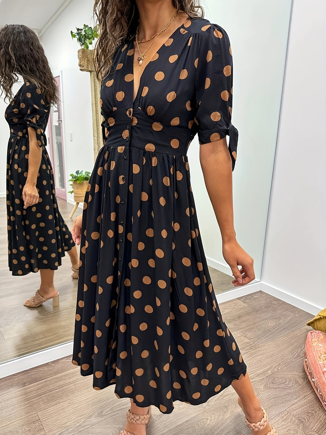 Elegant women's black polka dot A-line midi dress featuring a V-neck & chic tie sleeves for a sophisticated look.