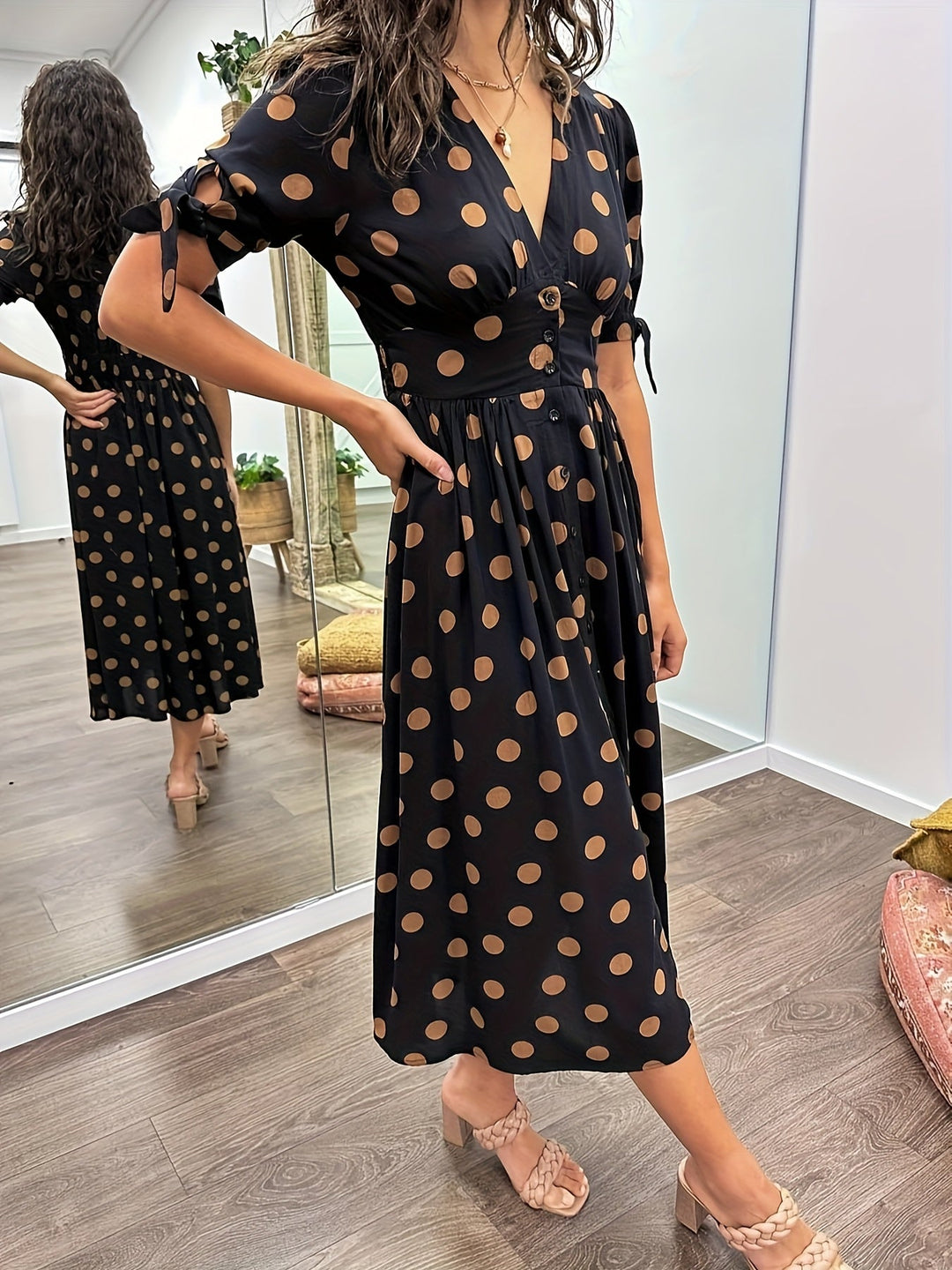 Stylish black polka dot midi dress for women. Chic, elegant, and perfect for a spring or summer party outfit.