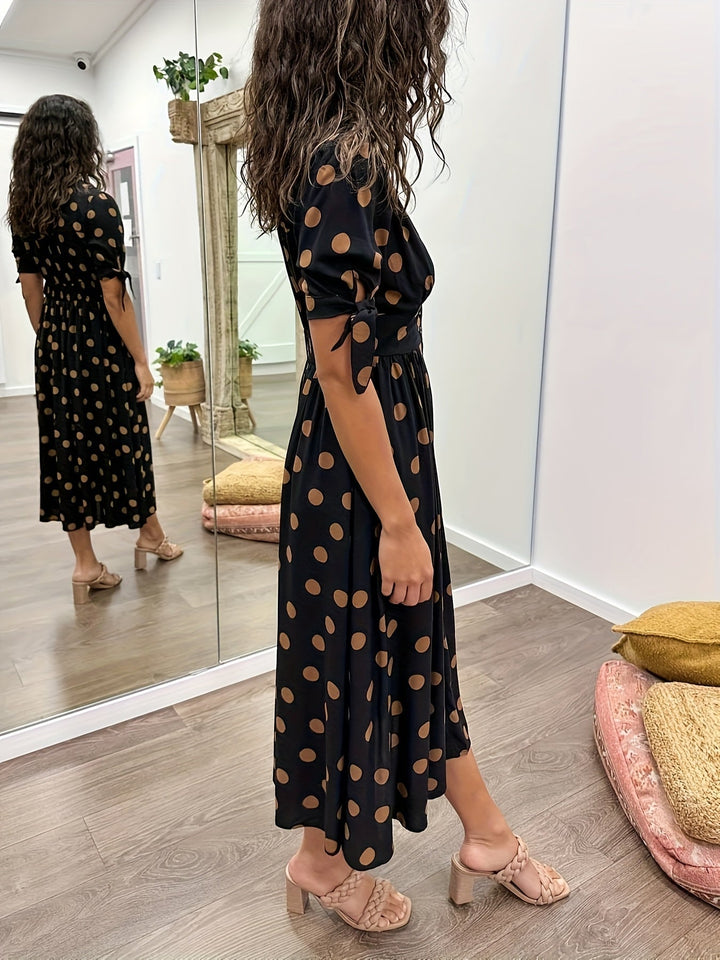 Fashionable women's black polka dot midi dress. Chic A-line, V-neck, tie sleeves for spring & summer elegance.