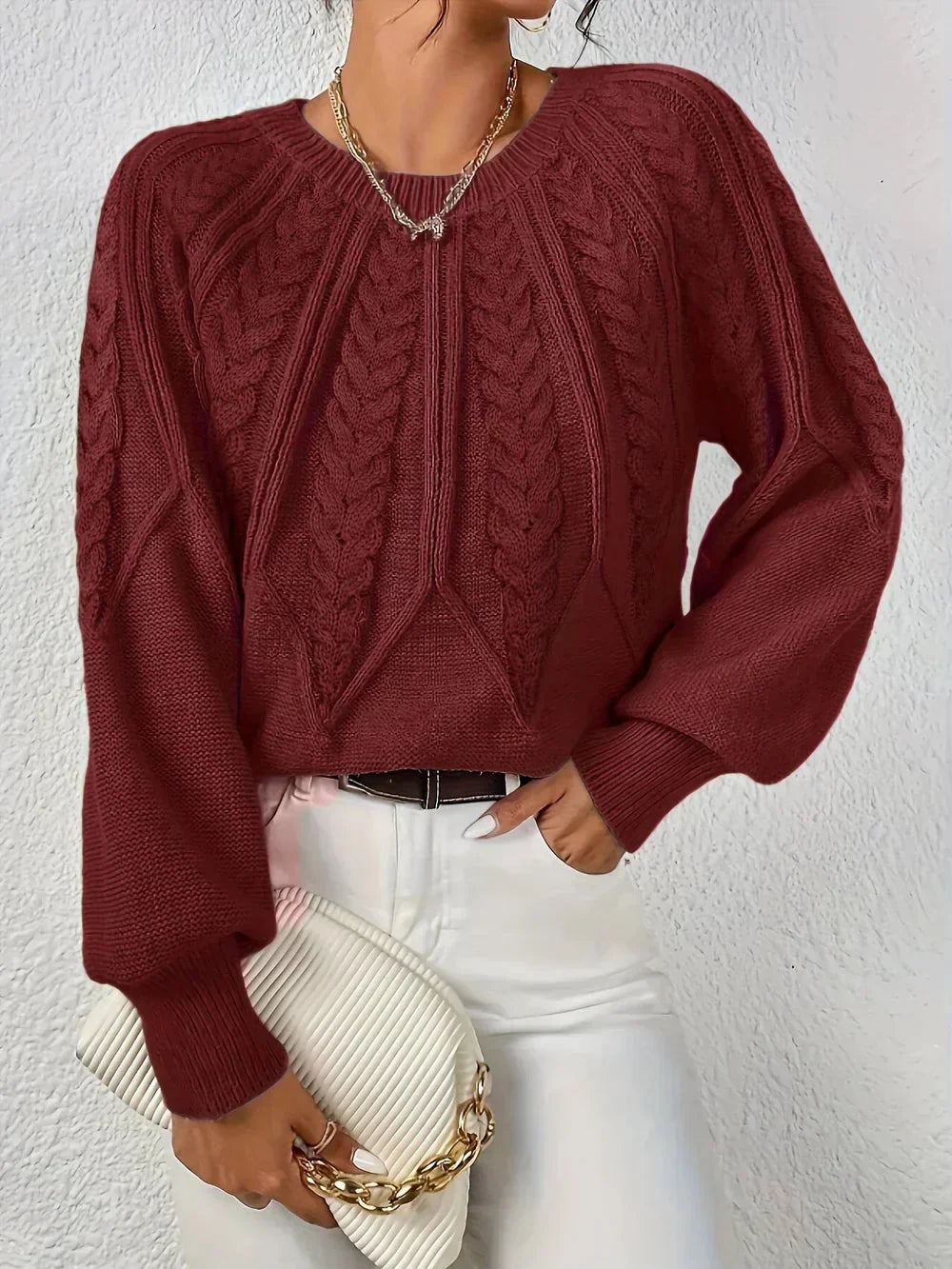 Elegant women's knit pullover, featuring cozy cable texture and stylish voluminous sleeves. Versatile winter fashion.