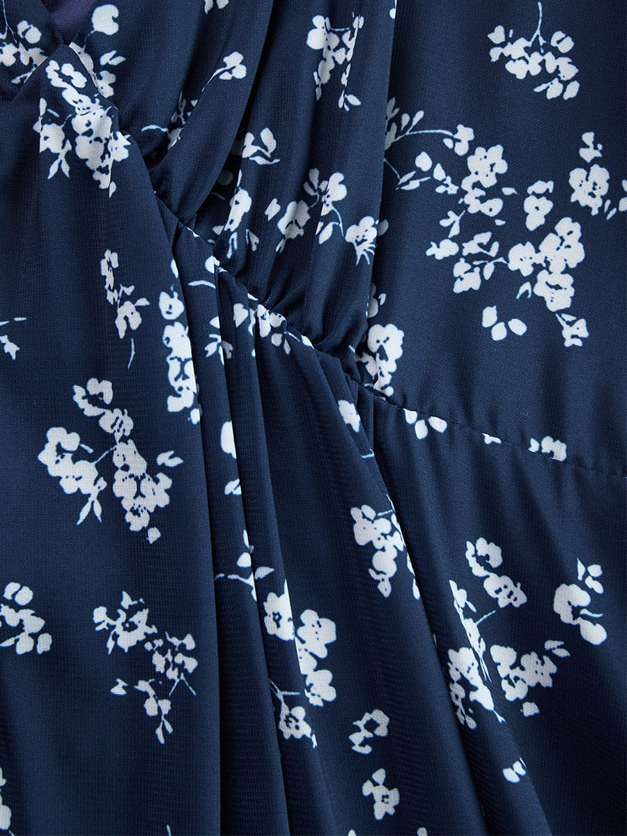 Fashionable women's floral halter dress, with ruched details and a striking asymmetrical hemline.