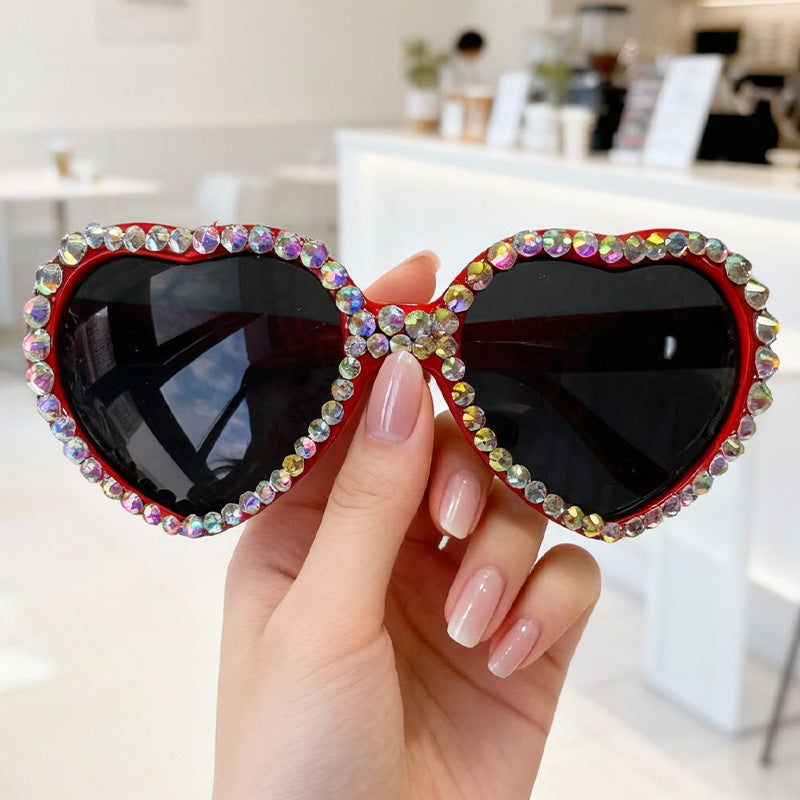 Sparkling rhinestone heart sunglasses for women, glamorous UV protection eyewear for a summer look.