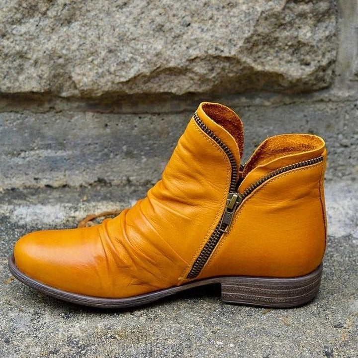 Stylish women's ruched leather ankle boots featuring convenient side-zip & comfortable low heel for everyday wear.