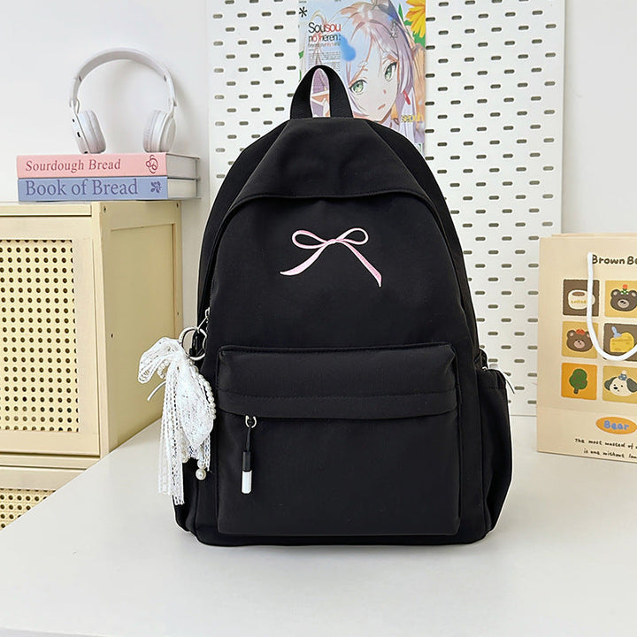 Cute women's fashion backpack, minimalist design with an elegant bow detail, perfect for school or daily wear.