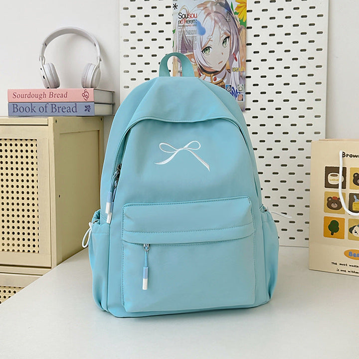 Functional women's travel backpack, minimalist style with a chic bow. Great for school, daily commutes, & trips.