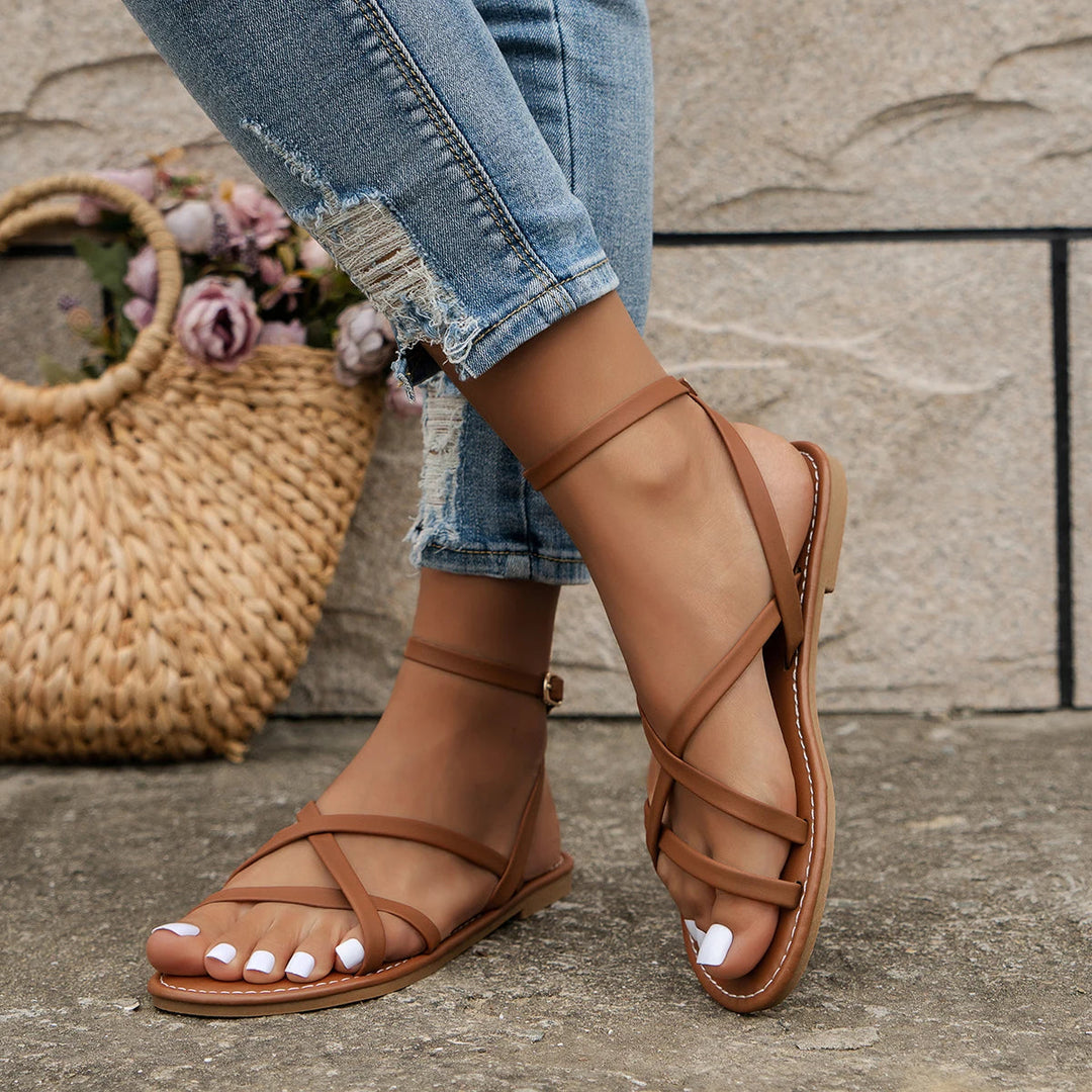 Modern women's criss-cross flat sandals, designed for comfortable summer wear, made from vegan leather.