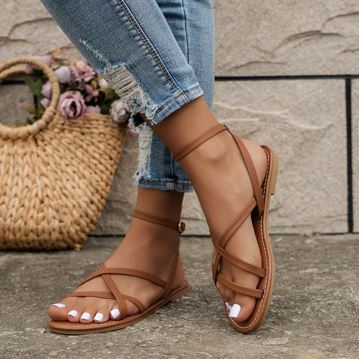 Modern women's criss-cross flat sandals, designed for comfortable summer wear, made from vegan leather.