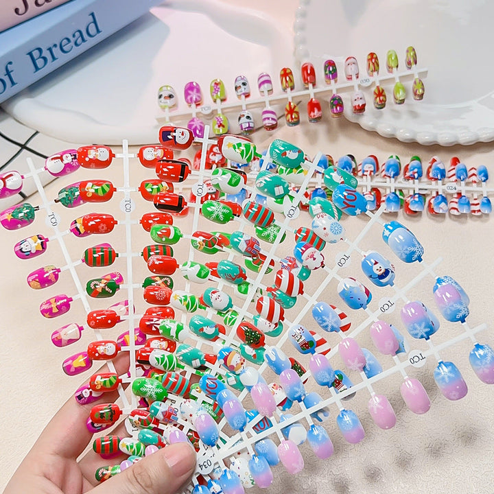 Children's festive press-on nail set, 24 holiday designs, non-toxic & playful for kids.