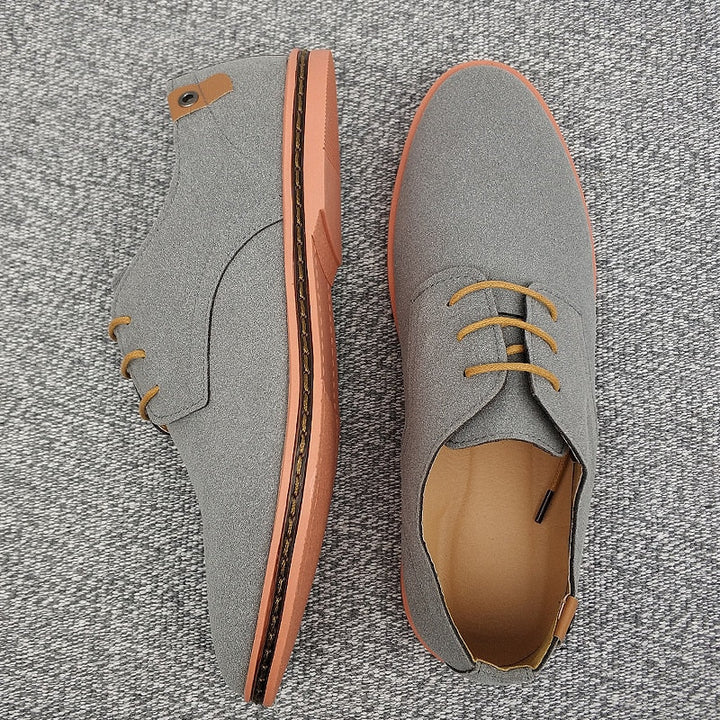 Luxurious leather grain on men's brown oxford shoes, indicating premium quality elegant formal footwear.