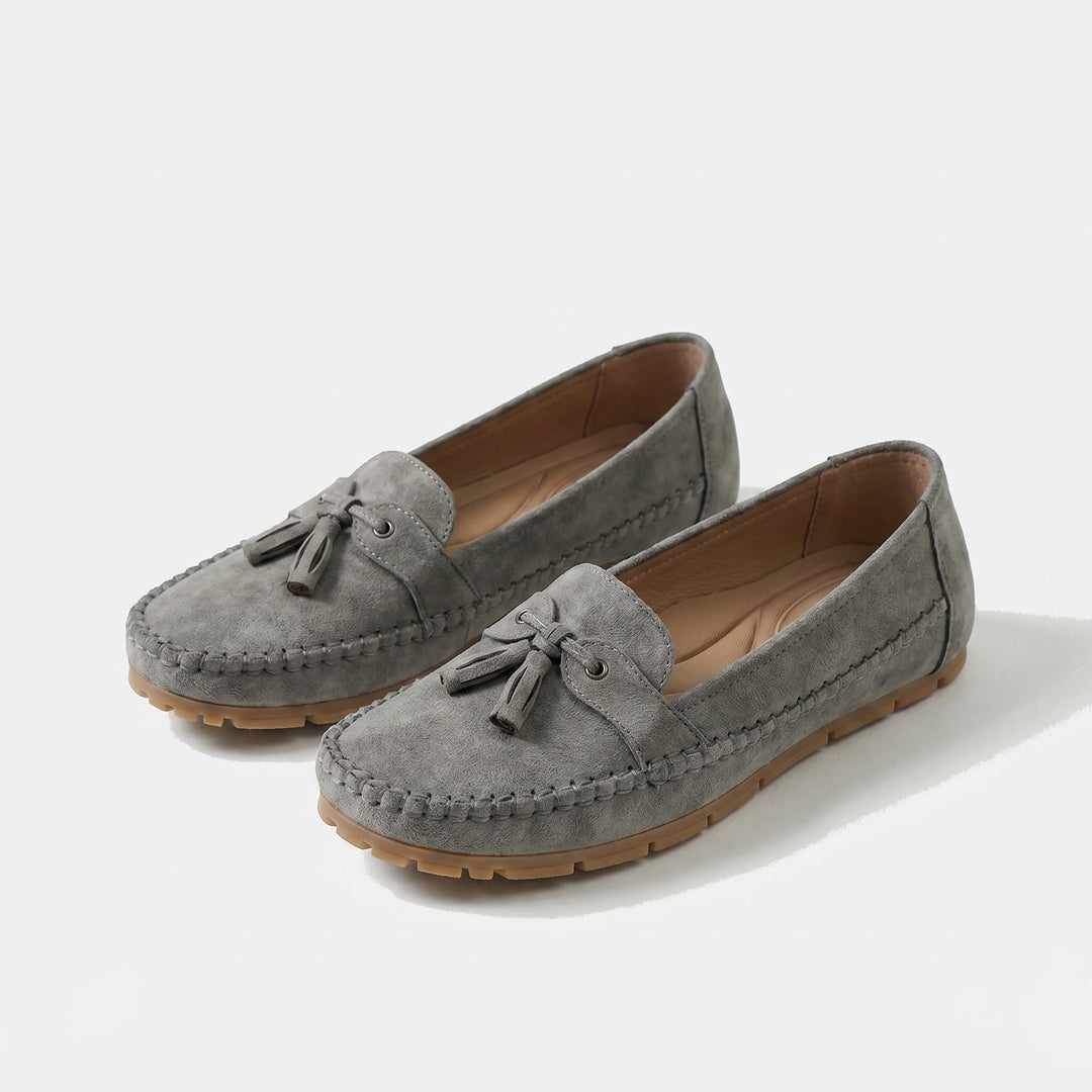 Pair of women's classic tassel loafers, comfortable slip-on shoes for office or casual outfits. Elegant footwear.